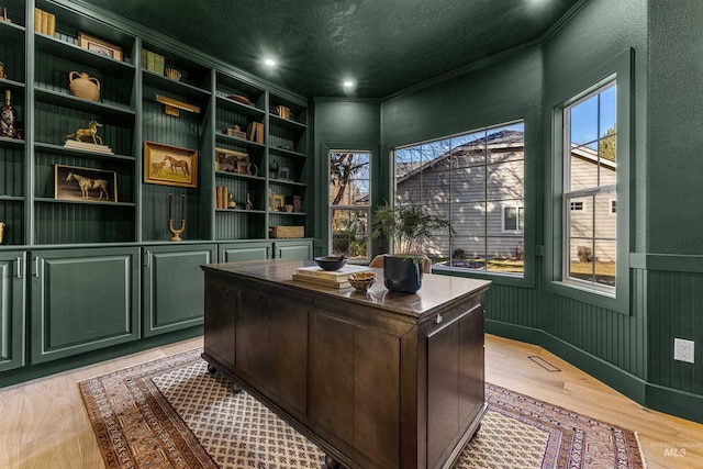 office with crown molding, built in features, a textured ceiling, and light hardwood / wood-style flooring