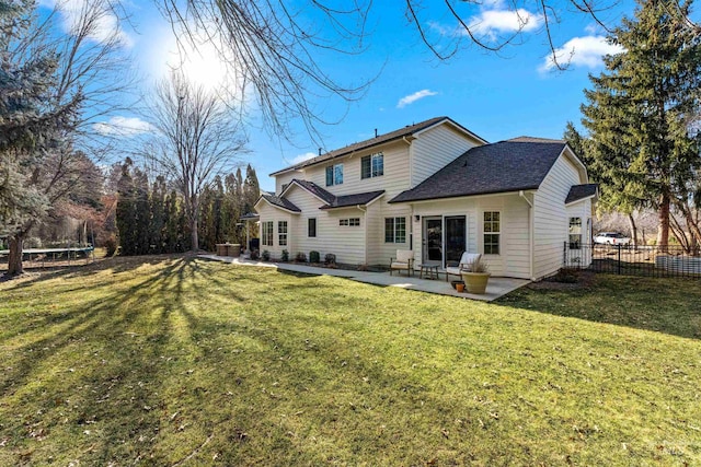 rear view of house featuring a trampoline, a patio area, and a lawn