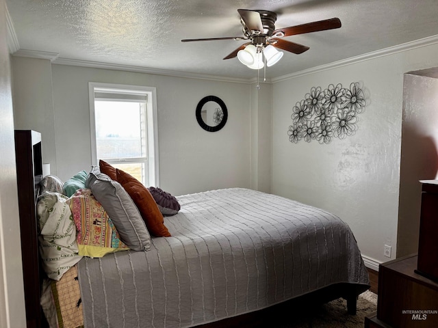 bedroom with ceiling fan, a textured ceiling, and ornamental molding