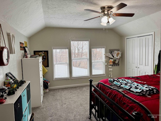 bedroom with light carpet, a textured ceiling, vaulted ceiling, ceiling fan, and a closet