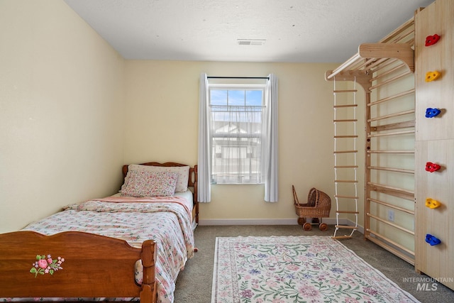 bedroom featuring a textured ceiling, carpet floors, visible vents, and baseboards