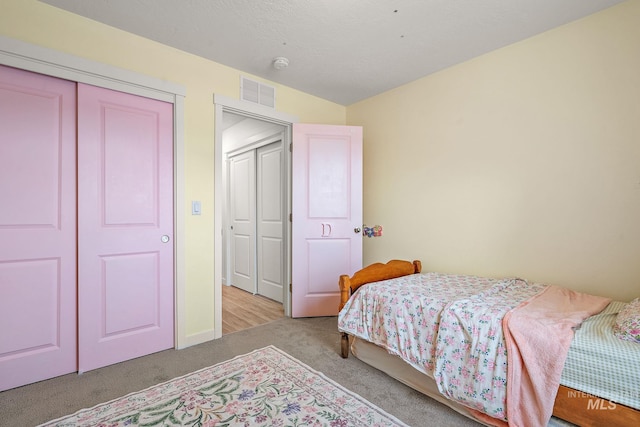 carpeted bedroom featuring a closet and visible vents