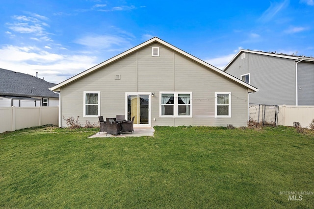 rear view of property featuring a patio, a lawn, and a fenced backyard