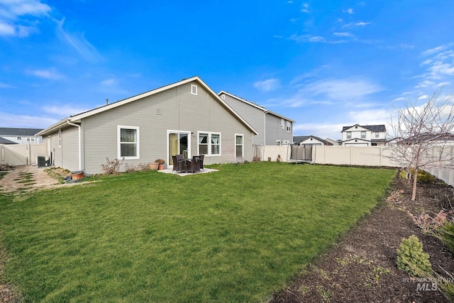 back of property with central air condition unit, a patio area, a fenced backyard, and a lawn