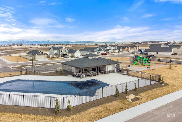 pool featuring playground community, a patio area, fence, and a residential view