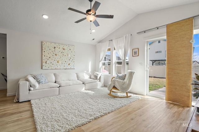 living area featuring visible vents, ceiling fan, vaulted ceiling, light wood-style floors, and recessed lighting