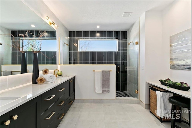 bathroom with vanity, a textured ceiling, and walk in shower