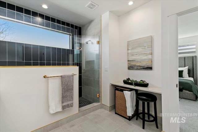 bathroom featuring a tile shower and tile patterned floors