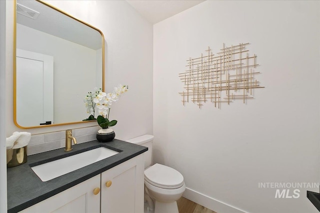 bathroom with vanity, toilet, and wood-type flooring