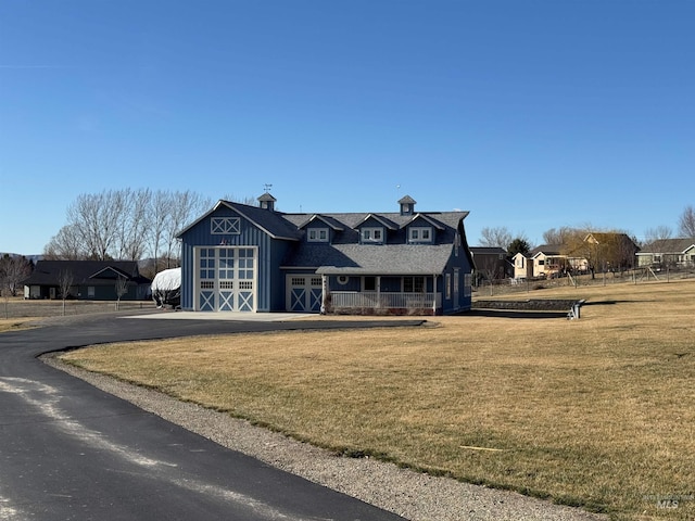 view of front of house with a barn, a front lawn, and an outdoor structure