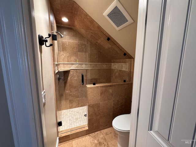 bathroom featuring toilet, a shower stall, and visible vents