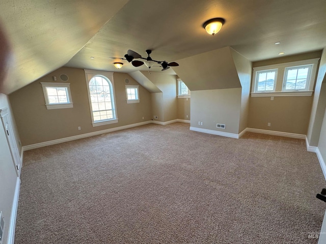 bonus room featuring a wealth of natural light, light carpet, visible vents, and baseboards