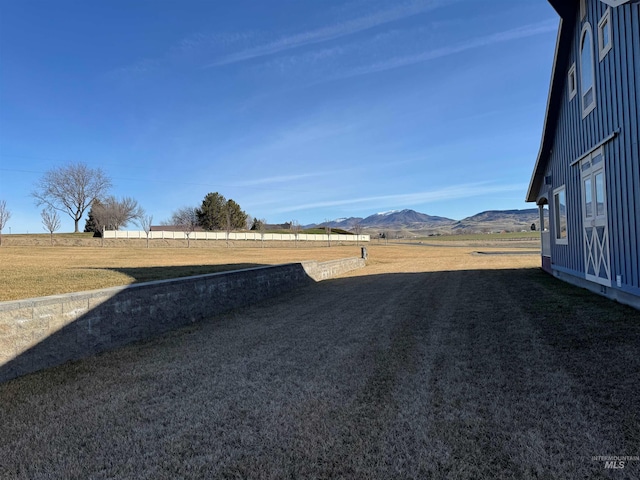 view of yard with a rural view and a mountain view