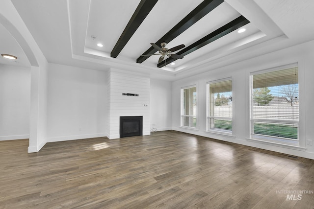 1734 Shoal Point Ave, Middleton, ID 83644 - unfurnished living room featuring a large fireplace, baseboards, a raised ceiling, and wood finished floors