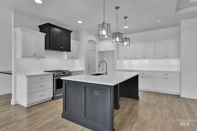 1734 Shoal Point Ave, Middleton, ID 83644 - kitchen featuring tasteful backsplash, gas stove, white cabinetry, a kitchen island with sink, and a sink