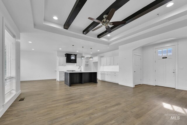 1734 Shoal Point Ave, Middleton, ID 83644 - unfurnished living room featuring visible vents, a raised ceiling, arched walkways, and recessed lighting