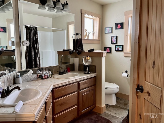 bathroom featuring a shower with shower curtain, vanity, and toilet