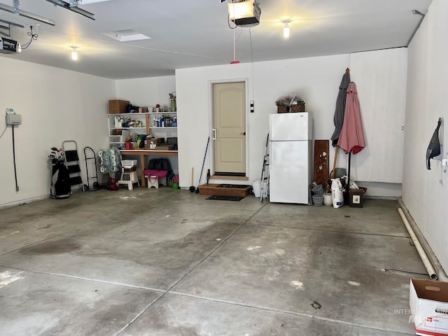 garage featuring white refrigerator and a garage door opener