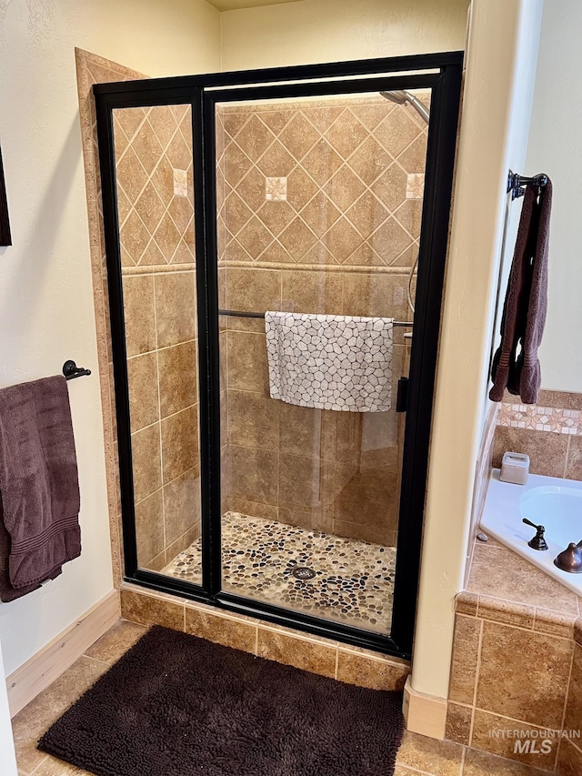 bathroom featuring shower with separate bathtub