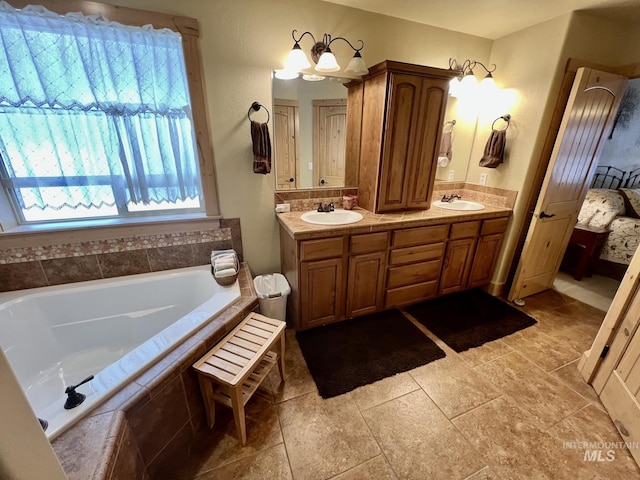 bathroom featuring vanity, tiled bath, and an inviting chandelier