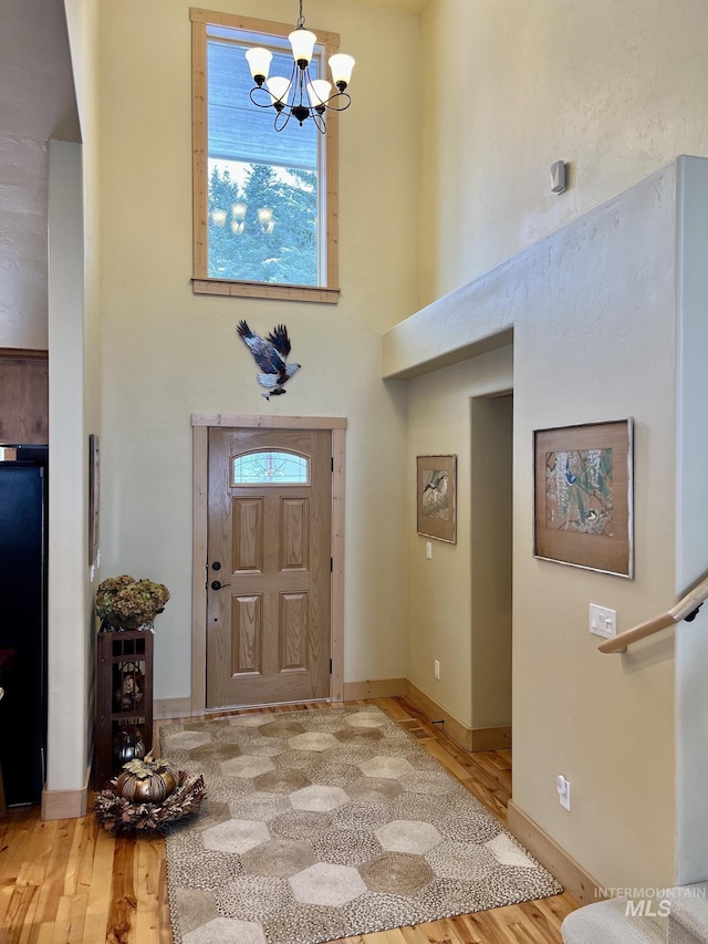 entryway featuring hardwood / wood-style floors, an inviting chandelier, and a healthy amount of sunlight