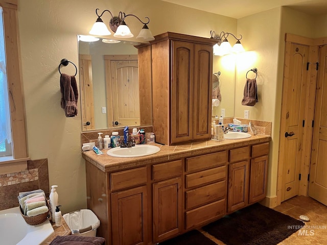 bathroom with tile patterned flooring, vanity, and a washtub