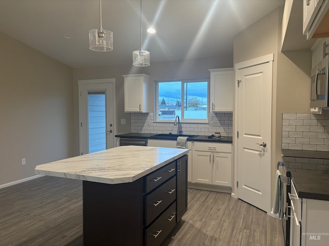 kitchen with white cabinetry, pendant lighting, wood-type flooring, decorative backsplash, and a kitchen island