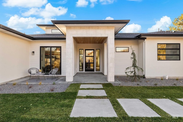 entrance to property with a yard and a patio