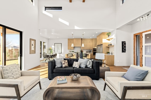 living room featuring a high ceiling and light hardwood / wood-style flooring