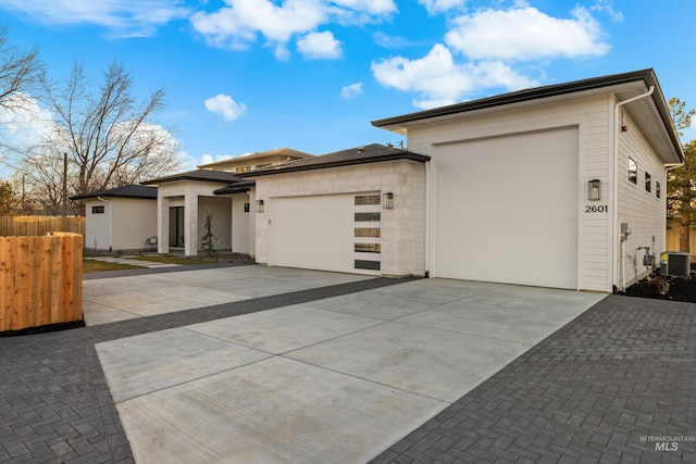 prairie-style home featuring cooling unit and a garage