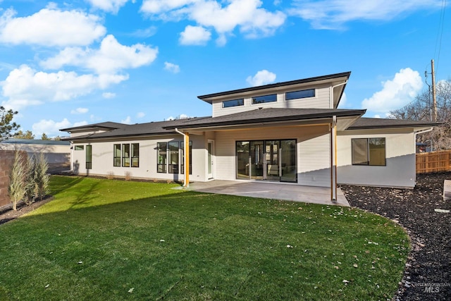 rear view of house featuring a patio area and a yard