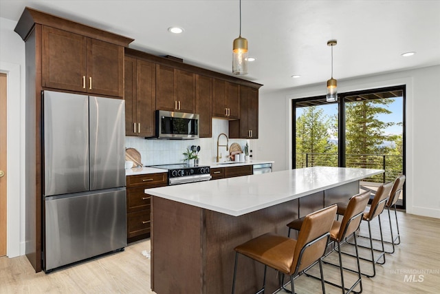 1678 Majestic View Dr, Mccall, ID 83638 - kitchen featuring appliances with stainless steel finishes, light wood finished floors, light countertops, decorative backsplash, and a kitchen island