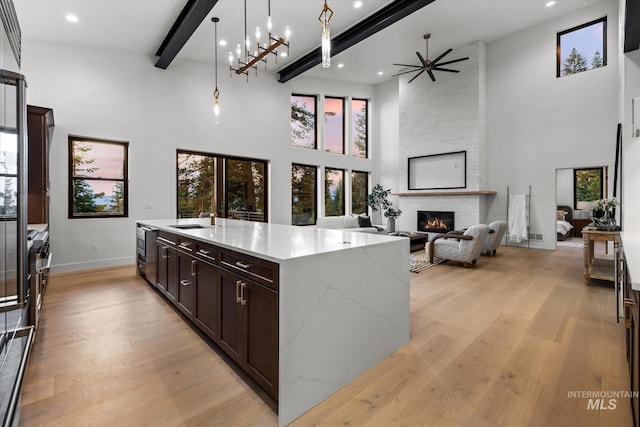 1678 Majestic View Dr, Mccall, ID 83638 - kitchen with a towering ceiling, open floor plan, light wood-style floors, a fireplace, and beamed ceiling