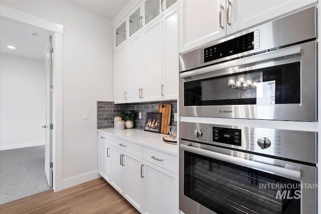 6874 N Fireball, Meridian, ID 83646 - kitchen with oven, tasteful backsplash, light countertops, and light wood-style flooring