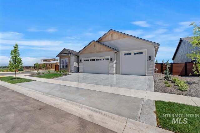 6874 N Fireball, Meridian, ID 83646 - view of front of house with an attached garage, board and batten siding, driveway, and stone siding