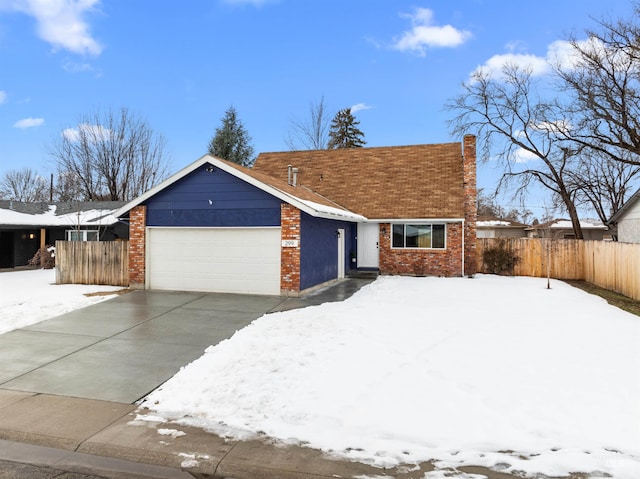 view of front of home featuring brick siding, fence, driveway, and an attached garage