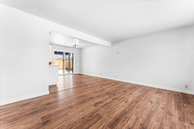 empty room with baseboards and wood finished floors