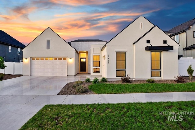 view of front of home featuring concrete driveway, a garage, and stucco siding