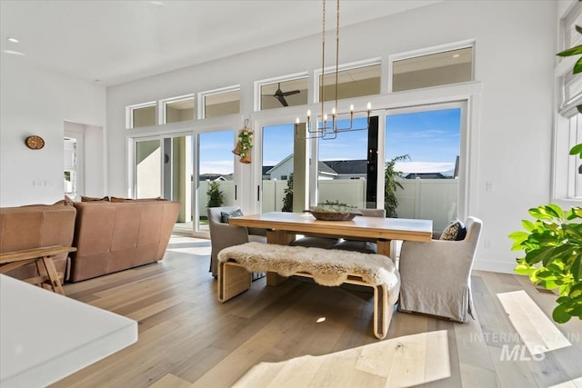 dining space featuring plenty of natural light, wood finished floors, and a chandelier