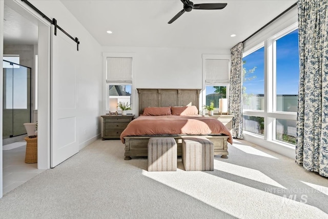 carpeted bedroom with a barn door, ceiling fan, and recessed lighting