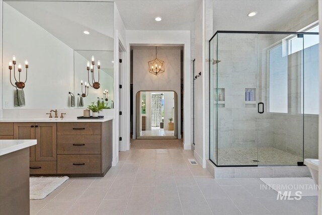 bathroom with a chandelier, tile patterned floors, a shower stall, vanity, and recessed lighting