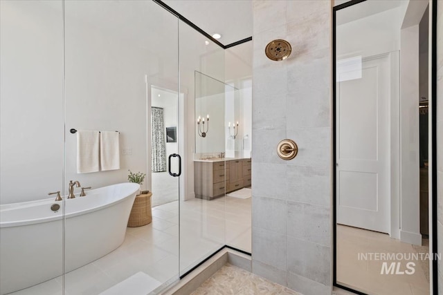 full bathroom featuring a stall shower, a freestanding bath, vanity, and tile patterned floors