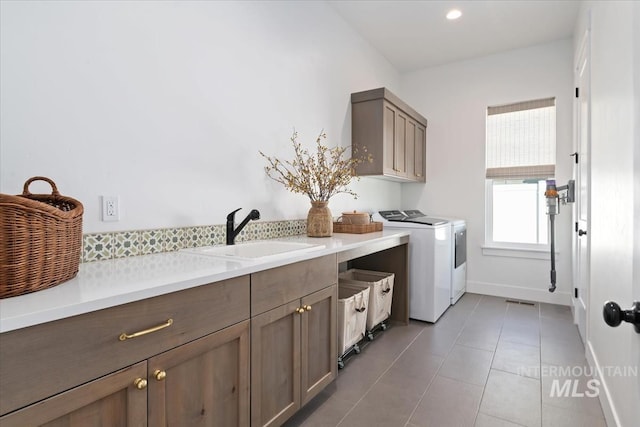 laundry room featuring cabinet space, washing machine and clothes dryer, light tile patterned floors, baseboards, and recessed lighting