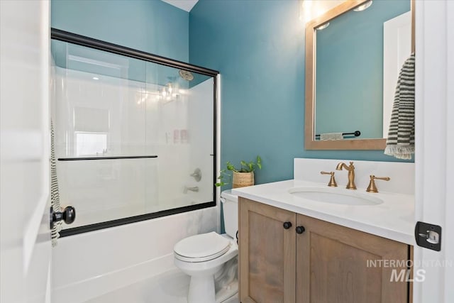 bathroom with vanity, toilet, and enclosed tub / shower combo