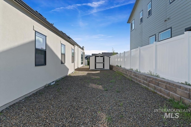 view of yard with a storage shed, fence, and an outdoor structure