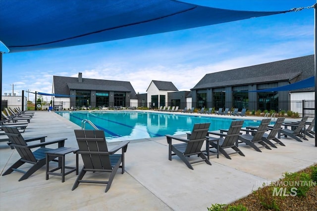 community pool with fence and a patio