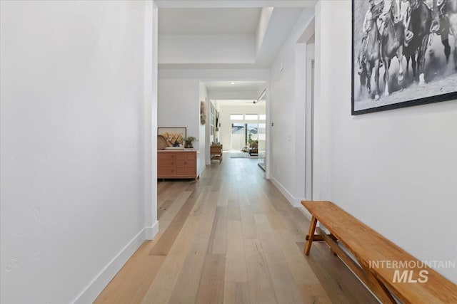 hall featuring light wood finished floors and baseboards