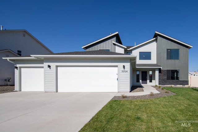 view of front facade with a garage, driveway, board and batten siding, and a front yard