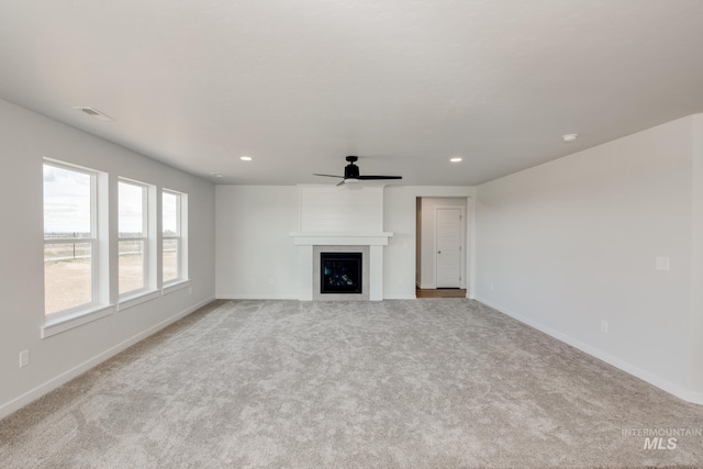 unfurnished living room featuring light carpet, ceiling fan, a fireplace, and recessed lighting