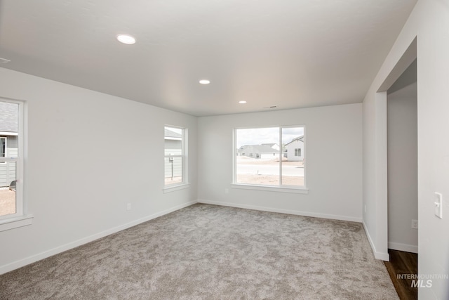 empty room with carpet floors, visible vents, baseboards, and recessed lighting